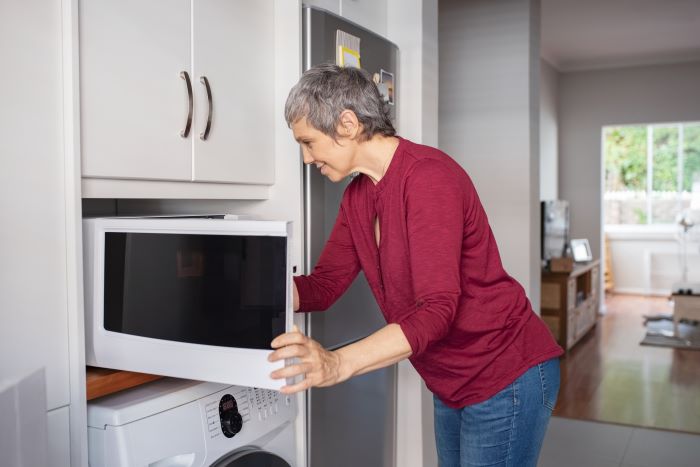 Senior woman cooking with a microwave.Cooking Tips and Recipes for Seniors in Emergencies